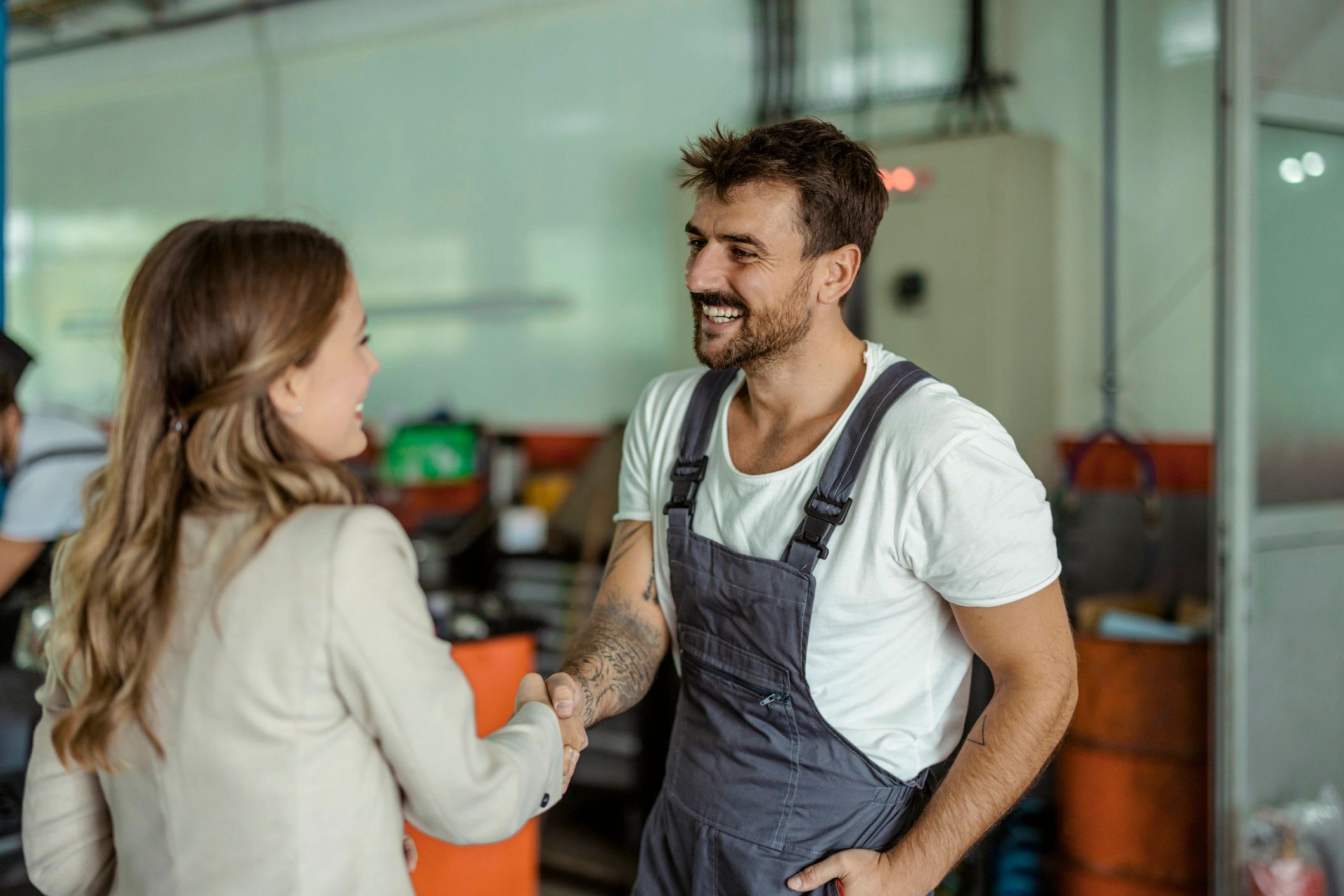 Auto mechanic and customer shaking hands after service